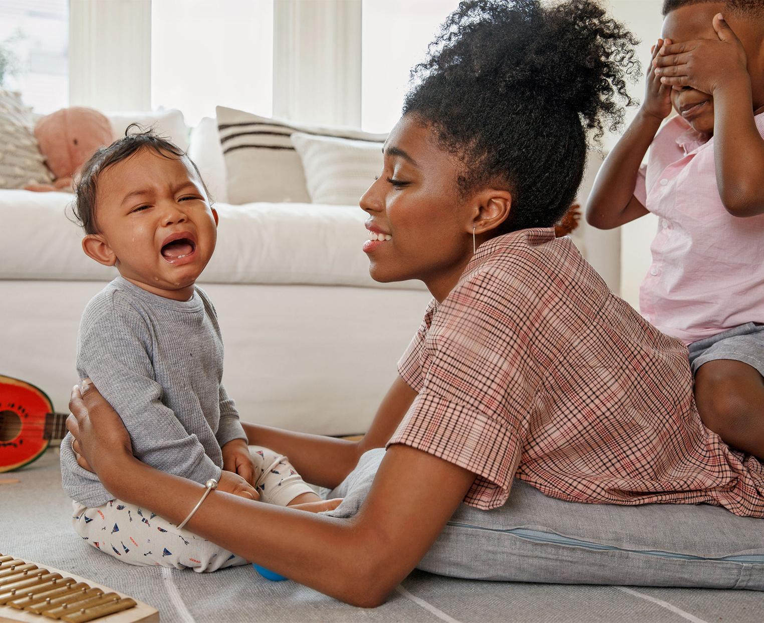 mother lying on floor with crying child