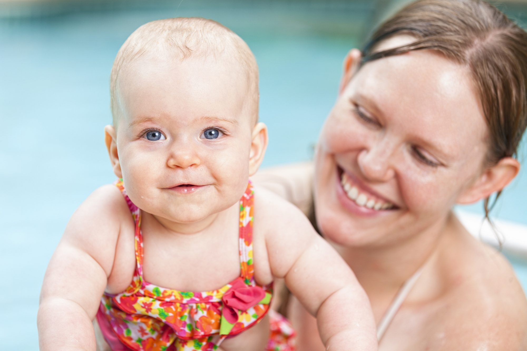 Baby and mother swimming in pool