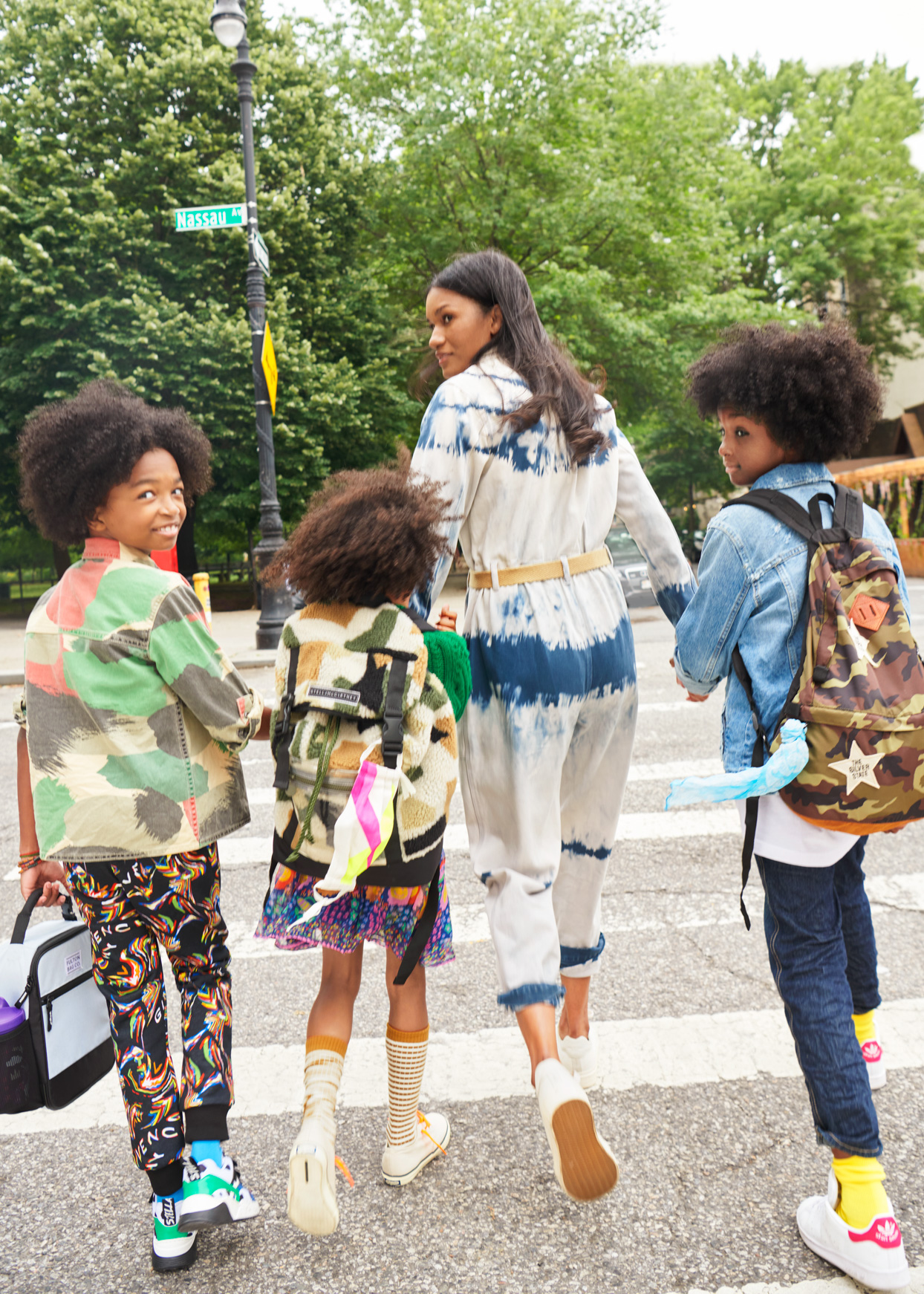 mom crossing street with three kids