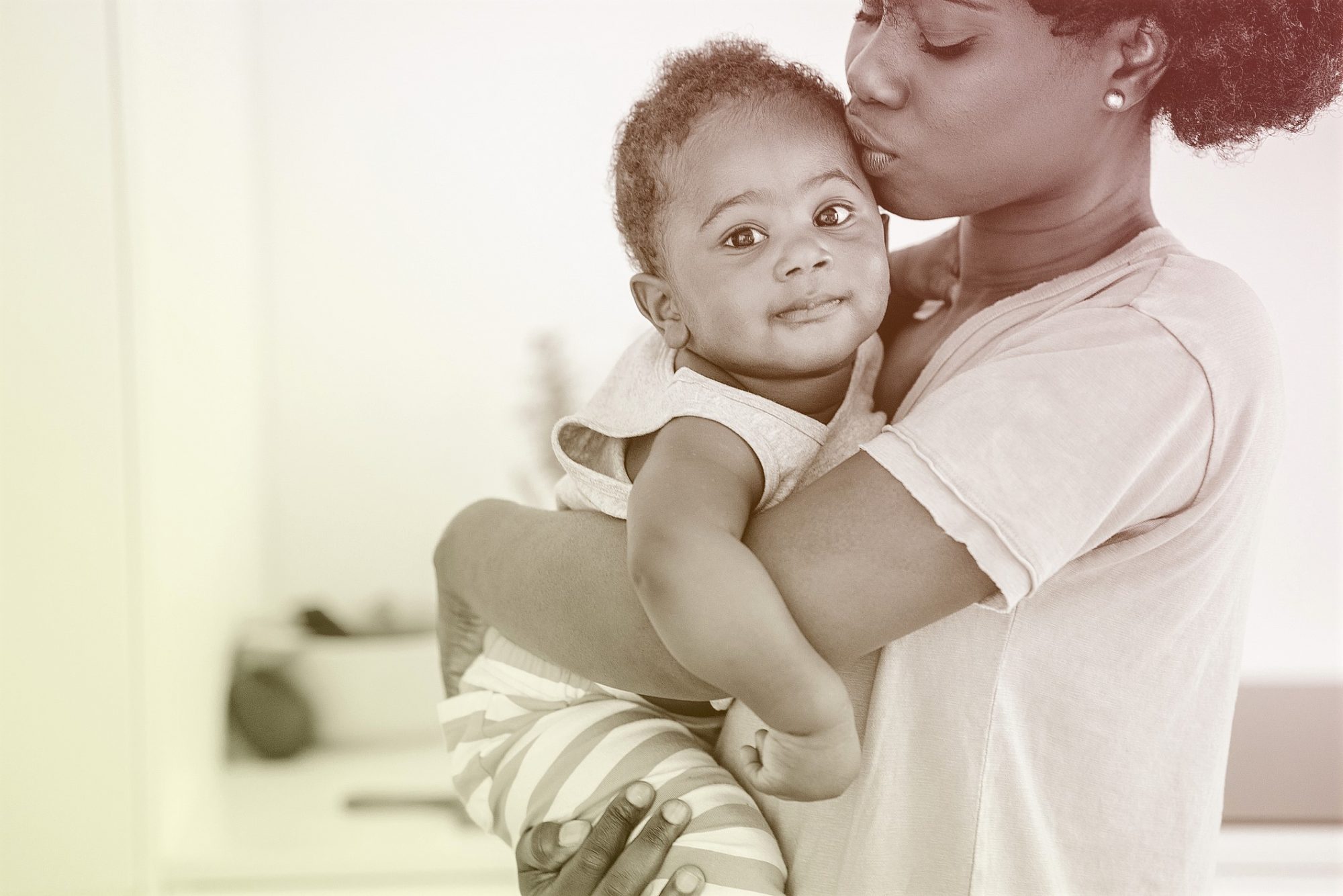 mother holding child and kissing forehead