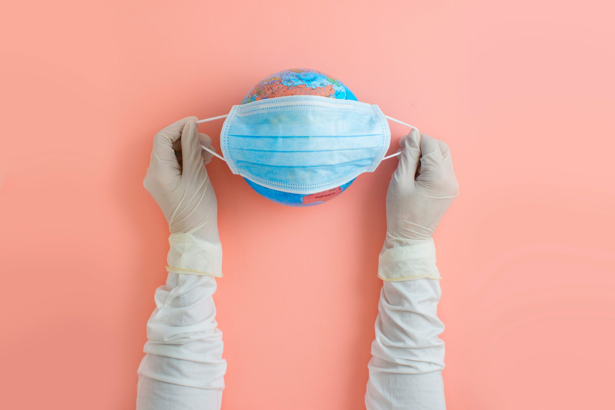 A still life of a globe with a mask on it.