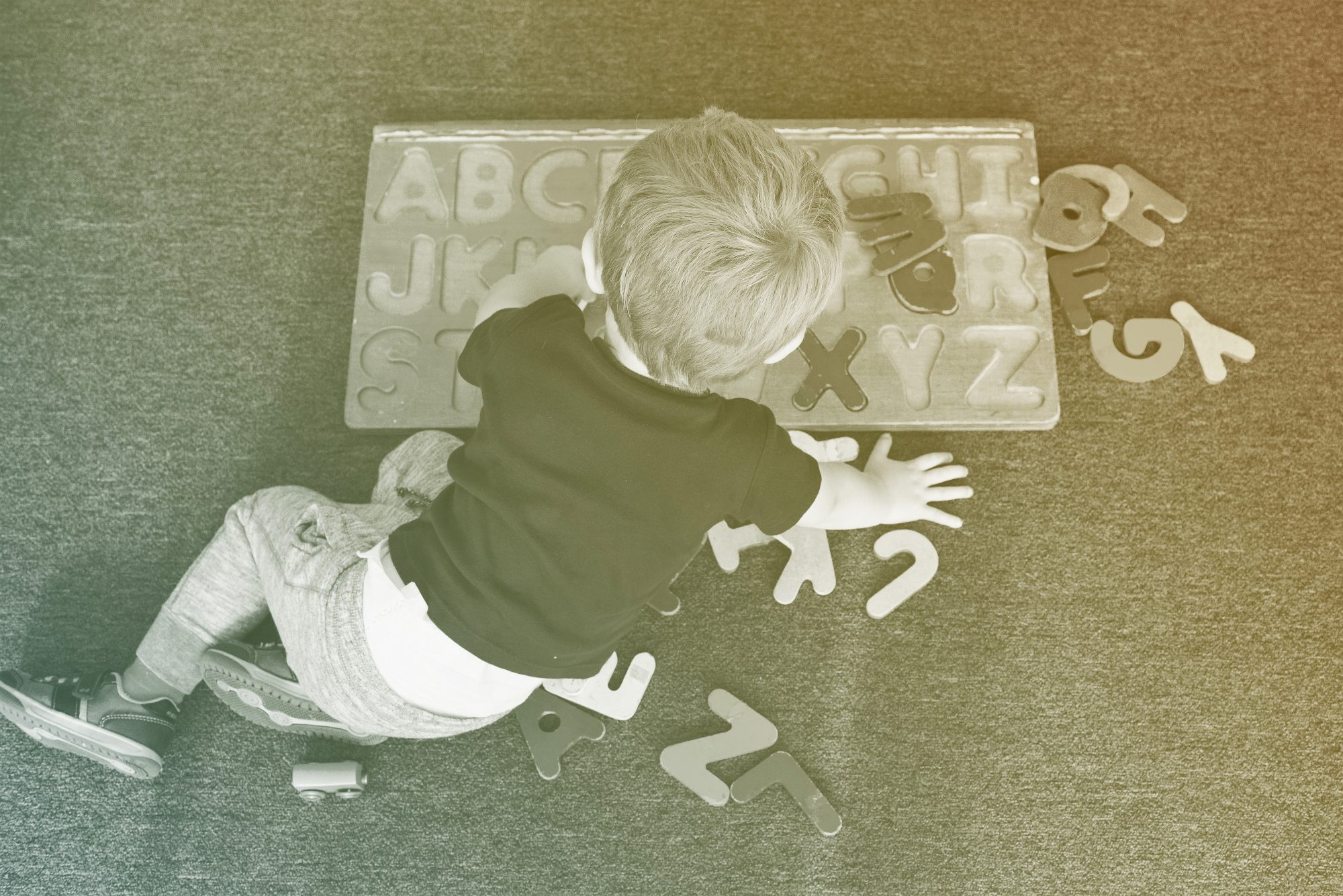 A little boy plays with an alphabet puzzle