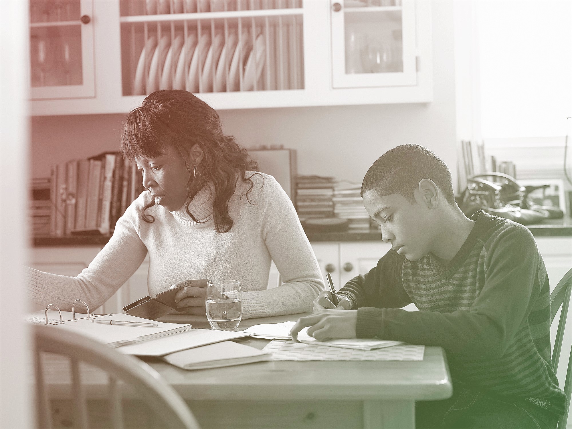 boy doing schoolwork with mother at home